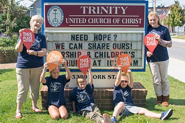Trinity UCC Members Holding Up "This Place Matters" Signs